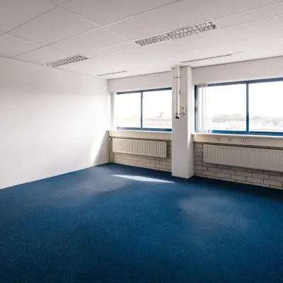 Vacant office space with blue carpet and large windows at Kabelweg 24, Amsterdam Sloterdijk, available for rent.