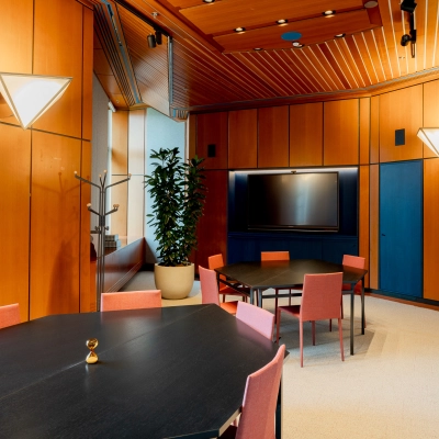 Bright office space at Bijlmerplein 888, Amsterdam South East, featuring stylish wooden walls, modern lighting, and neatly arranged tables for office rental opportunities.