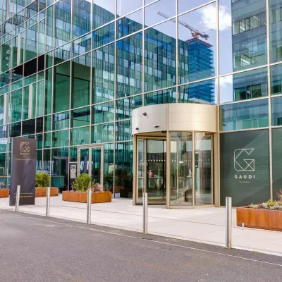 Entrance of an office building at Herikerbergweg 288, ideal for office space rental in Amsterdam South East. Features modern architecture with reflective glass facade.