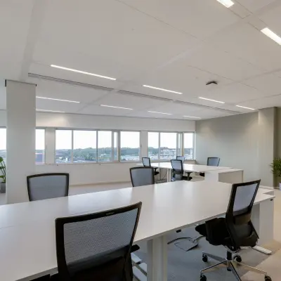 Spacious office to rent at Herikerbergweg 288, Amsterdam South East, featuring modern desks and chairs with large windows allowing ample natural light.