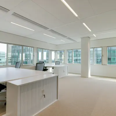 Bright office space rental at Herikerbergweg 290, Amsterdam South East, featuring modern desks and chairs in a light-filled room.