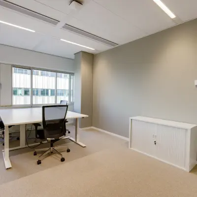 Modern office space for rent at Herikerbergweg 290 in Amsterdam South East, featuring a light-filled room with two workstations and ergonomic chairs.