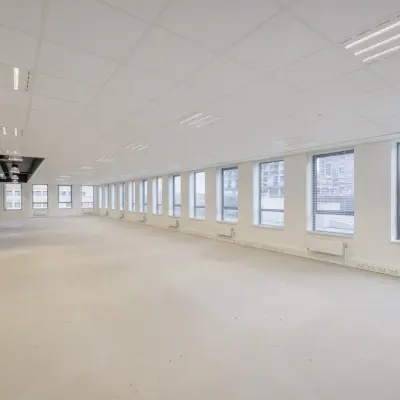 An unfurnished office space for rent at Hogehilweg 24, Amsterdam South East, featuring large windows and ample lighting, ideal for customizing to your business needs.