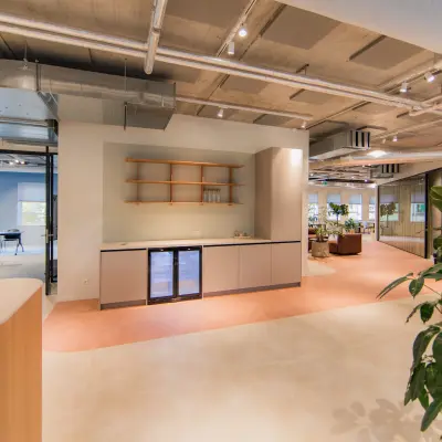 Modern office space at Hullenbergweg 109-135, Amsterdam South East, featuring stylish interiors with light flooring, a kitchenette, and contemporary furnishings, ideal for office space rental.