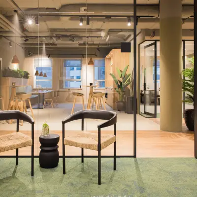 Modern office space in Amsterdam South East at Hullenbergweg 109-135, featuring a stylish interior with seating, glass partitions, and greenery, perfect for an office to rent.