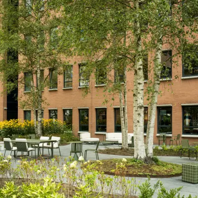 Outdoor seating area at office to rent on Hullenbergweg 109-135, Amsterdam South East, featuring trees and modern patio furniture.