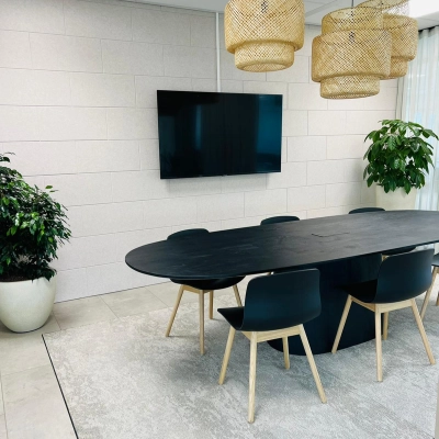 Modern office space at Laarderhoogtweg 7-19, Amsterdam South East featuring a sleek conference room with a central table, chairs, and a large wall-mounted screen, ideal for meetings.