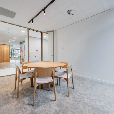 A furnished meeting area in the office space at Laarderhoogtweg 7-19, Amsterdam South East, ideal for office space rental with a round wooden table and chairs.