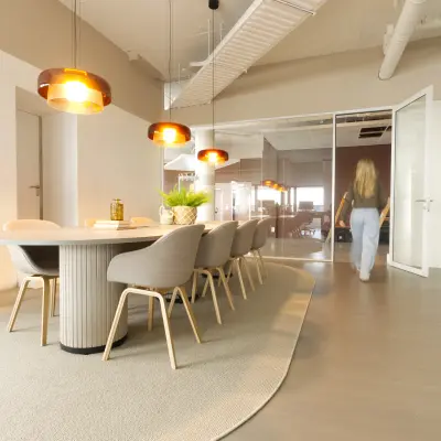 Modern office space at Luttenbergweg 8, Amsterdam South East with stylish furnishings and a meeting table, ideal for office space rental.
