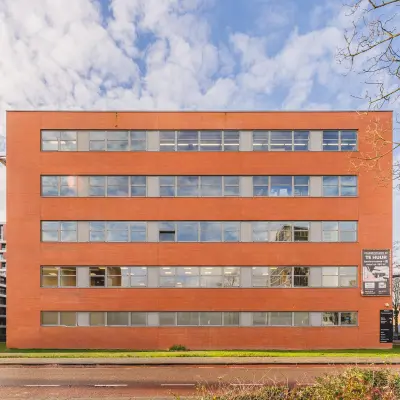 Exterior view of a brick office building at Paasheuvelweg 20, Amsterdam South East, highlighting available office space rental options.