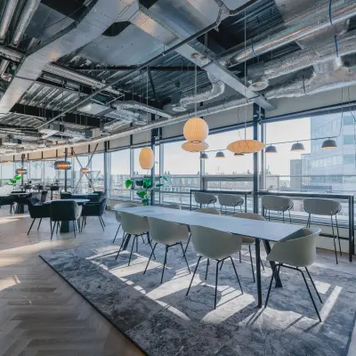Modern office space with large windows, offering bright, open workspaces and a stylish meeting area at Bos en Lommerplein 280 in Amsterdam West, available for rent office space.