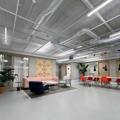 Modern office space at Haarlemmerweg 331, Amsterdam West, featuring a chic seating area and vibrant red chairs ideal for rental.