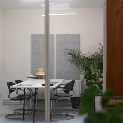 Modern office space at Hondiusstraat 7H in Amsterdam West, featuring a sleek conference room with a white table, black chairs, and minimalist decor. Ideal for office space rental.