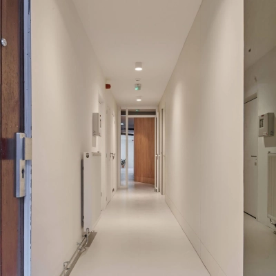 Bright, well-lit corridor in an office building located at Hondiusstraat 7H, Amsterdam West, ideal for seamless office space rental with modern design elements.