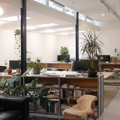 Spacious and modern office interior at Hondiusstraat 7H in Amsterdam West, featuring stylish furnishings, plants, and multiple workstations. Ideal for those seeking office space rental in a vibrant location.