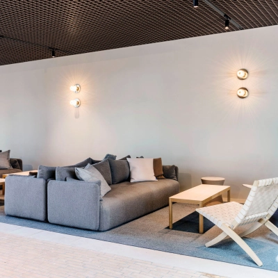 Stylish office lounge in Amsterdam West featuring modern seating and soft lighting, offering comfortable space for work or meetings. Ideal for office space rental.