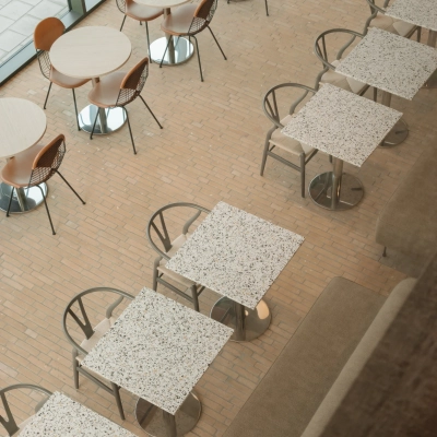 Modern office space rental in Amsterdam West features an airy area with several tables and chairs, ideal for meetings or collaboration.