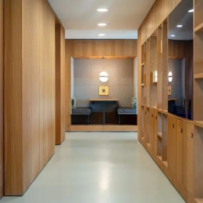 Modern hallway at Barbara Strozzilaan 101, Amsterdam Zuidas, featuring sleek wood paneling and built-in storage, ideal for office space rental.