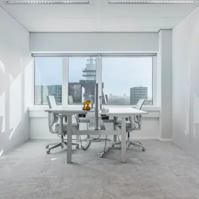 Bright office space at Barbara Strozzilaan 101, Amsterdam Zuidas, featuring large windows with a city view and modern furniture. Ideal for those seeking office space rental in a vibrant location.