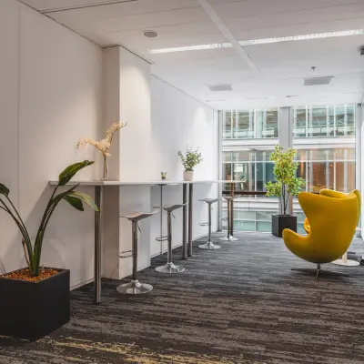 Furnished office space for rent at Claude Debussylaan 10, Amsterdam Zuidas, with modern seating and plants creating a welcoming atmosphere.