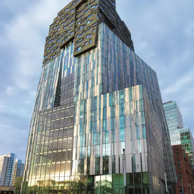 Modern glass office building in Amsterdam Zuidas, featuring a striking facade at Claude Debussylaan 80-134, suitable for office space rental.
