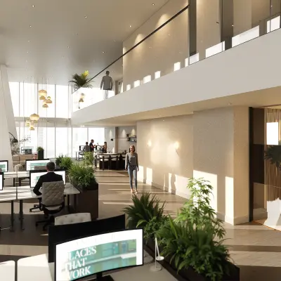 Modern office space rental at Claude Debussylaan 80-134, Amsterdam Zuidas, featuring workstations with people engaged in business activities in a well-lit, furnished interior.