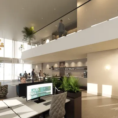 Modern office space for rent at Claude Debussylaan 80-134, Amsterdam Zuidas, featuring stylish workstations and a lounge area. People are engaging in collaborative work activities.