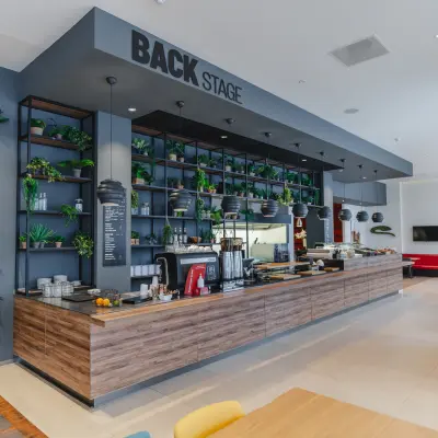 Spacious and modern pantry area at De Boelelaan 30, Amsterdam Zuidas, ideal for office space rental, featuring a large wooden counter with seating and greenery accents.