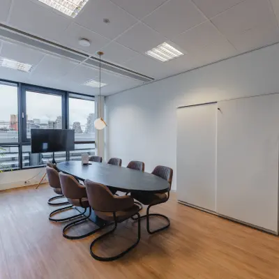 Bright conference room at De Boelelaan 30, Amsterdam Zuidas featuring a large table and chairs, ideal for office space rental.