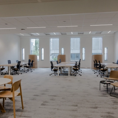 Spacious furnished office space rental at Fred. Roeskestraat 100, Amsterdam Zuidas, featuring multiple desks and chairs with large windows providing natural light. Ideal office to rent for collaborative work.
