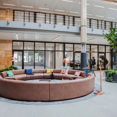 Spacious office lounge area with circular seating and plants at Fred. Roeskestraat 100, ideal for office space rental in Amsterdam Zuidas.
