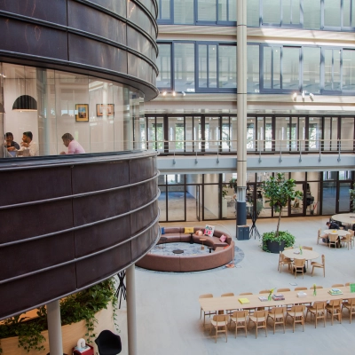 Spacious office at Fred. Roeskestraat 100, Amsterdam Zuidas, with people engaged in a meeting, showcasing modern office space rental options.