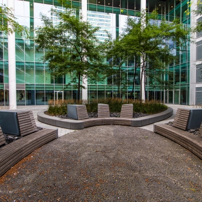 Outdoor seating area with modern benches and greenery at Gustav Mahlerplein, perfect for a break near your office space rental in Amsterdam Zuidas.