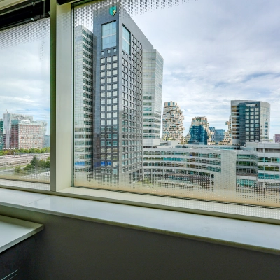 View from a window in an office to rent at Gustav Mahlerplein, Amsterdam Zuidas, showcasing city skyscrapers.