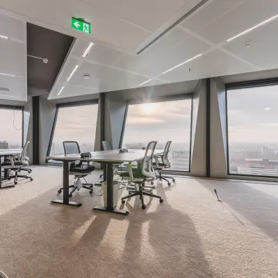 Spacious office to rent in Amsterdam Zuidas, with large windows and modern furnishings, offering a bright workspace ideal for creative collaboration.