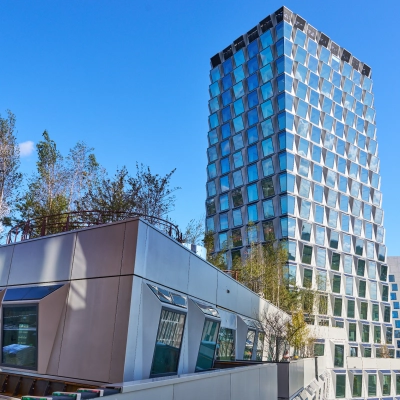 Exterior view of a modern office building at Hildegard Von Bingenstraat 44, Amsterdam Zuidas, with a unique facade and rooftop greenery. Ideal for those seeking office space rental in a vibrant location.