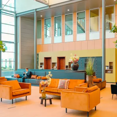 Spacious and bright office lounge at Jachthavenweg 109, Amsterdam Zuidas, offering comfortable seating with modern furnishings, ideal for informal meetings. Consider this vibrant office space rental for your next business move.