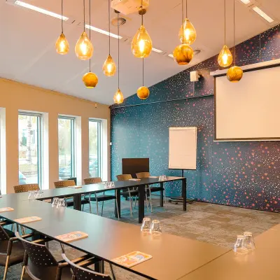 Spacious conference room at Jachthavenweg 109, Amsterdam Zuidas with modern lighting, large screen, and seating arrangement, ideal for office space rental.
