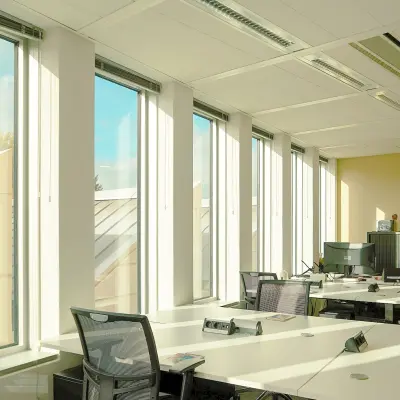 Bright, furnished office space rental in Amsterdam Zuidas with large windows and multiple workstations ready for use.