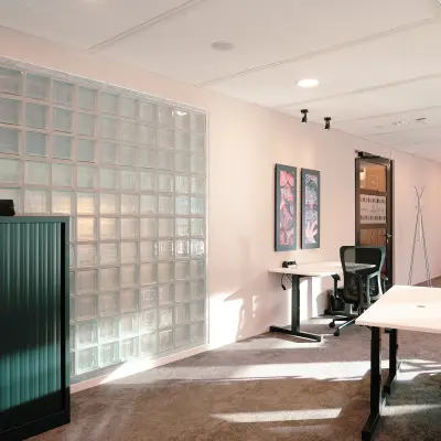Modern office space at Jachthavenweg 109, Amsterdam Zuidas, featuring glass partition, desks, and office chairs, ideal for rent office space.