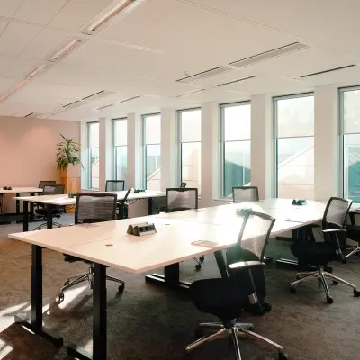 Bright and airy office space available for rent at Jachthavenweg 109, Amsterdam Zuidas, featuring multiple workstations with ergonomic chairs and large windows for natural light.