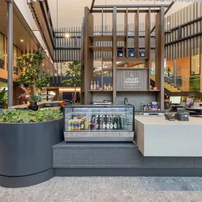 Modern office space at Jachthavenweg 109 in Amsterdam Zuidas featuring a stylish reception area with a beverage cooler and plants, ideal for those seeking office space rental.