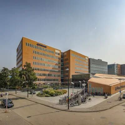 Exterior view of office buildings at Jachthavenweg 109, Amsterdam Zuidas, showing a modern design with a nearby bike parking area.
