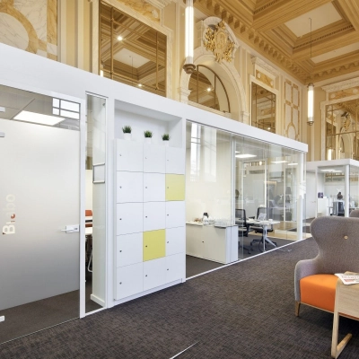 Elegant office space rental at Pelikaanstraat 3, Antwerp Center with glass-partitioned workspaces and comfortable seating.