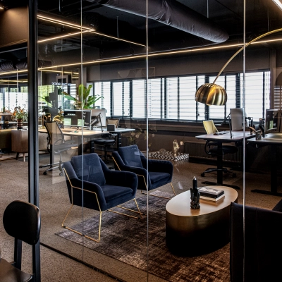 Modern office space in Apeldoorn with stylish furnishings, glass walls, and desks set up for work. Ideal for those looking to rent office space or interested in office space rental.