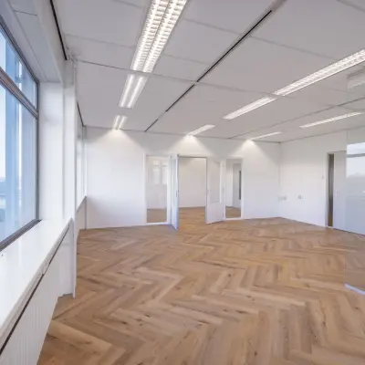 Spacious, well-lit office with herringbone flooring and large windows, available for office space rental on Oude Apeldoornseweg 41-45, Apeldoorn.