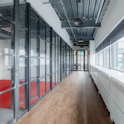 Spacious hallway with wooden flooring and large glass walls at Oude Apeldoornseweg 41-45, ideal for office space rental.