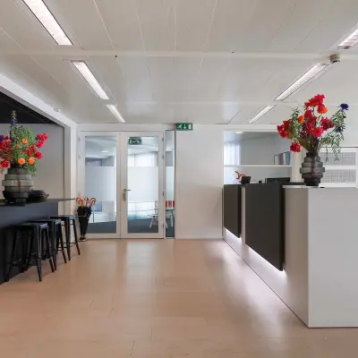 Modern office interior at Prins Willem-Alexanderlaan 301, Apeldoorn with contemporary furnishings and floral decorations, available for office space rental.