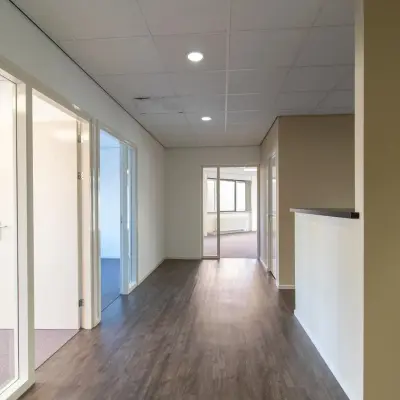 Hallway in an office at Prins Willem-Alexanderlaan 401, Apeldoorn, ideal for office space rental with rooms branching off. A sleek and neutral interior ready for rent.