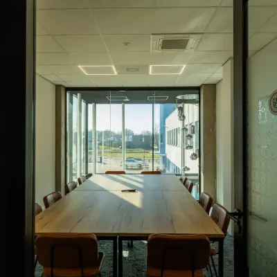 Bright office space with a large table and chairs located at Prins Willem Alexanderlaan 701, Apeldoorn, ideal for meetings or team collaborations. Perfect for office space rental.